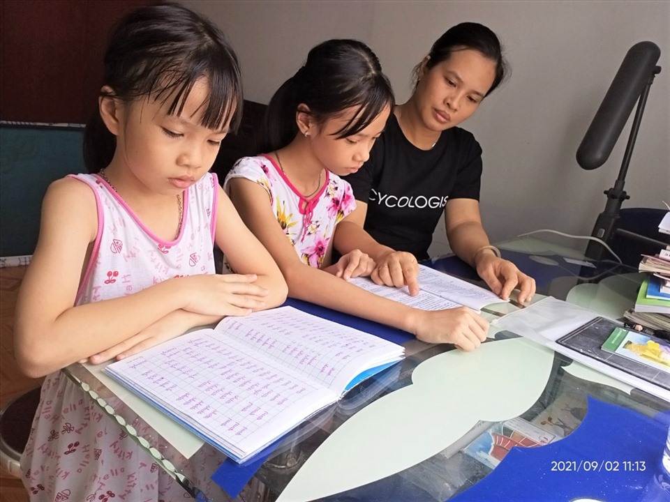 Trang thủ thời gian nghỉ ngơi, chị Nguyễn Thị Ánh Tuyết đang hướng dẫn các con học tập. Ảnh: Đức Long