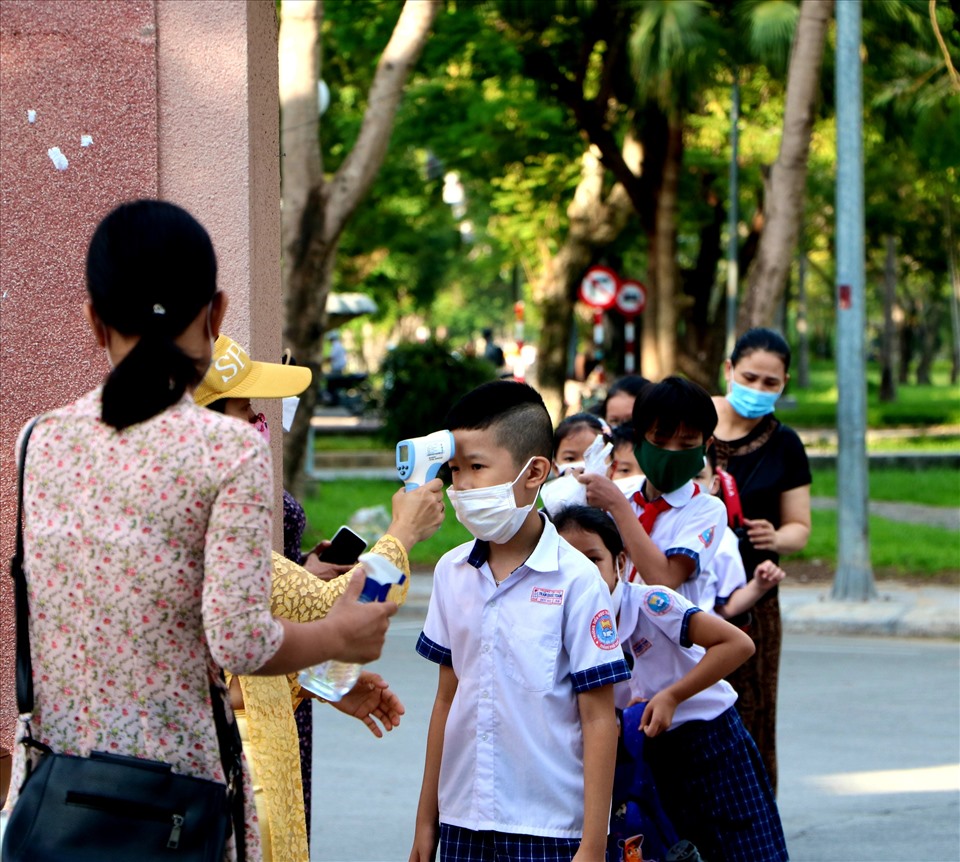 Trước khi vào trường, tất cả các học sinh đều được đo thân nhiệt.