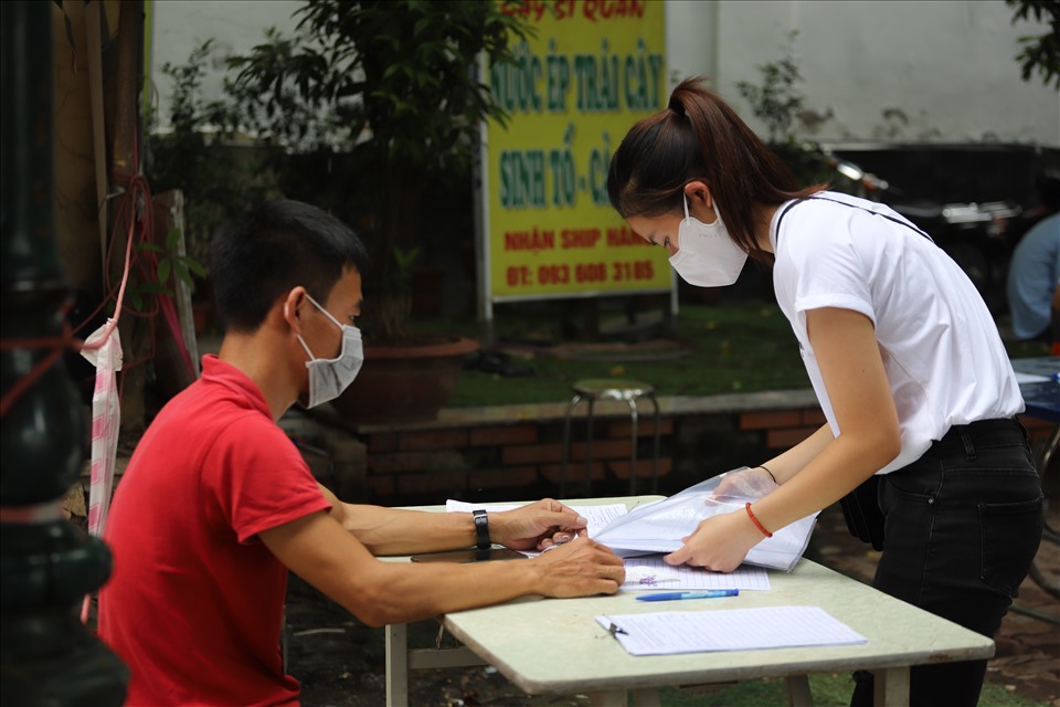 Người dân kê khai thông tin, ngồi chờ tới lượt làm thủ tục.