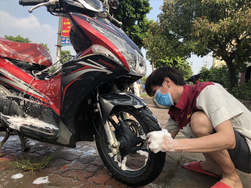 Anh Vi Văn Đông - nhân viên rửa xe máy trên đường