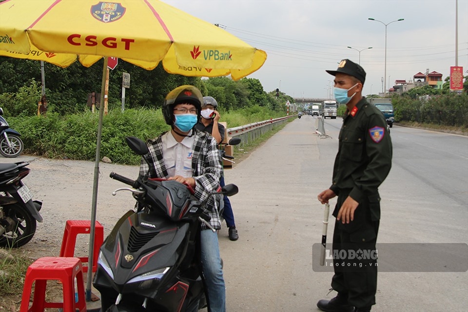 Cán bộ trực chốt kiểm soát hướng dẫn người dân tại Quốc lộ 5 (đoạn qua huyện Gia Lâm, Hà Nội). Ảnh T.Vương