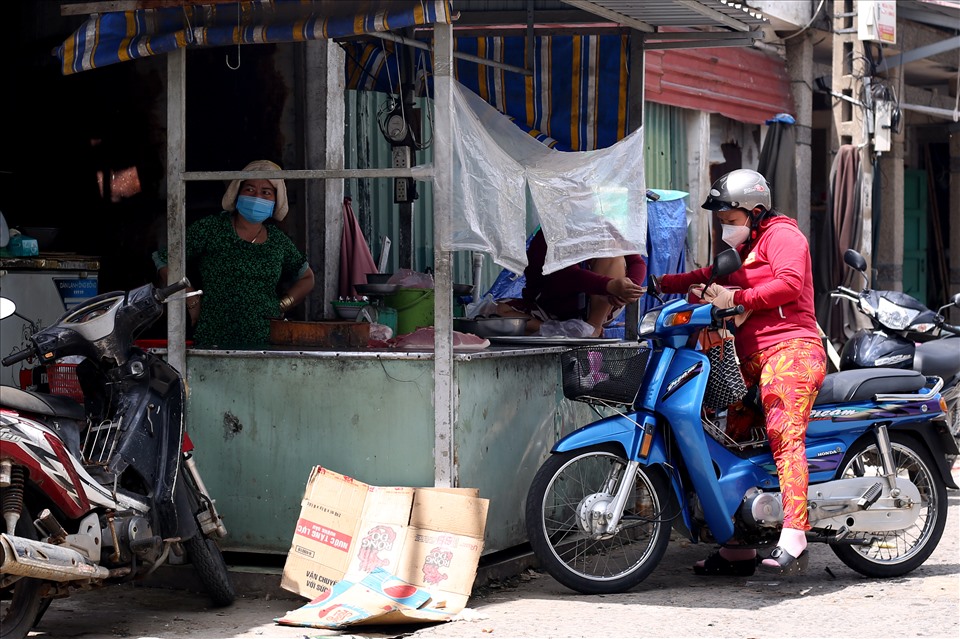 Người dân tại thị trấn Cần Thạnh được phát phiếu đi chợ 1 lần/tuần. Cả người mua và người bán đều chấp hành nghiêm các quy định phòng, chống dịch COVID-19.