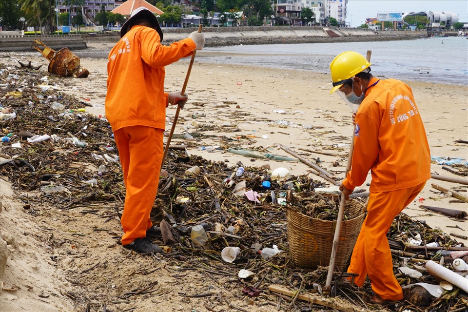 Công nhân vệ sinh cũng xuống biển dọn rác khi lượng rác tấp vào bờ biển khá nhiều. Ảnh: T.A