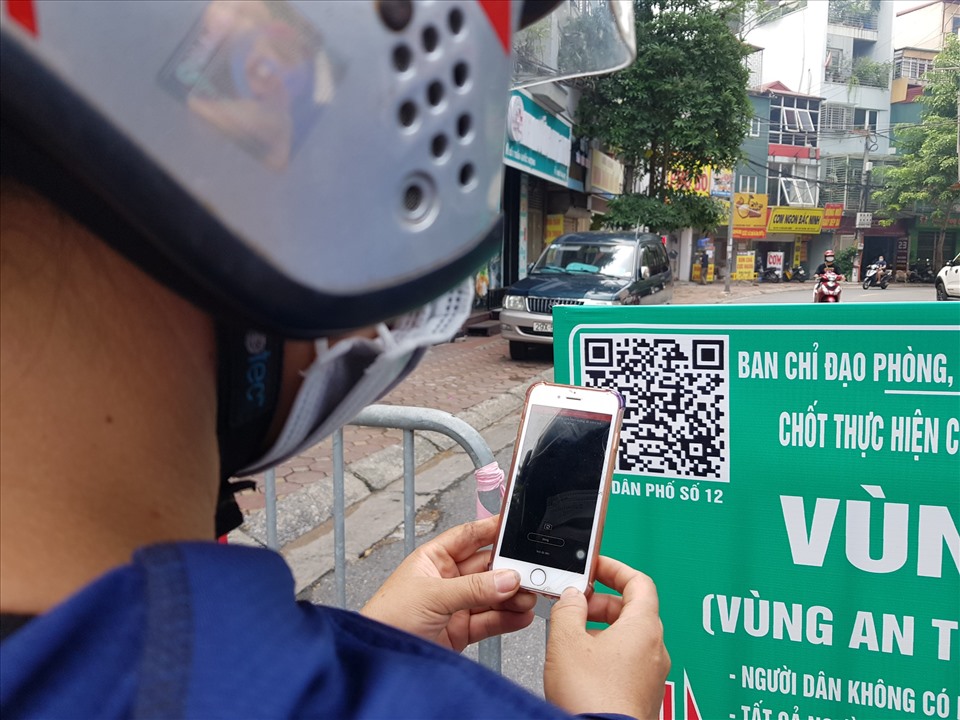 Người dân khai báo y tế bằng cách quét mã QR khi ra vào chốt kiểm soát trên phố Trần