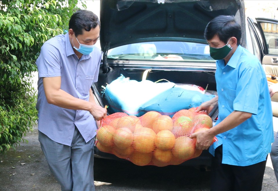 Ông Nguyễn Văn Chung, Chủ tịch Liên đoàn Lao động tỉnh Hà Giang (áo xanh) cùng ông Nguyễn Văn Giao, Quyền Giám đốc Sở y tế tỉnh Hà Giang vận chuyển rau, củ quả trao tặng cho 42 y, bác sĩ. Ảnh: Đức Trí