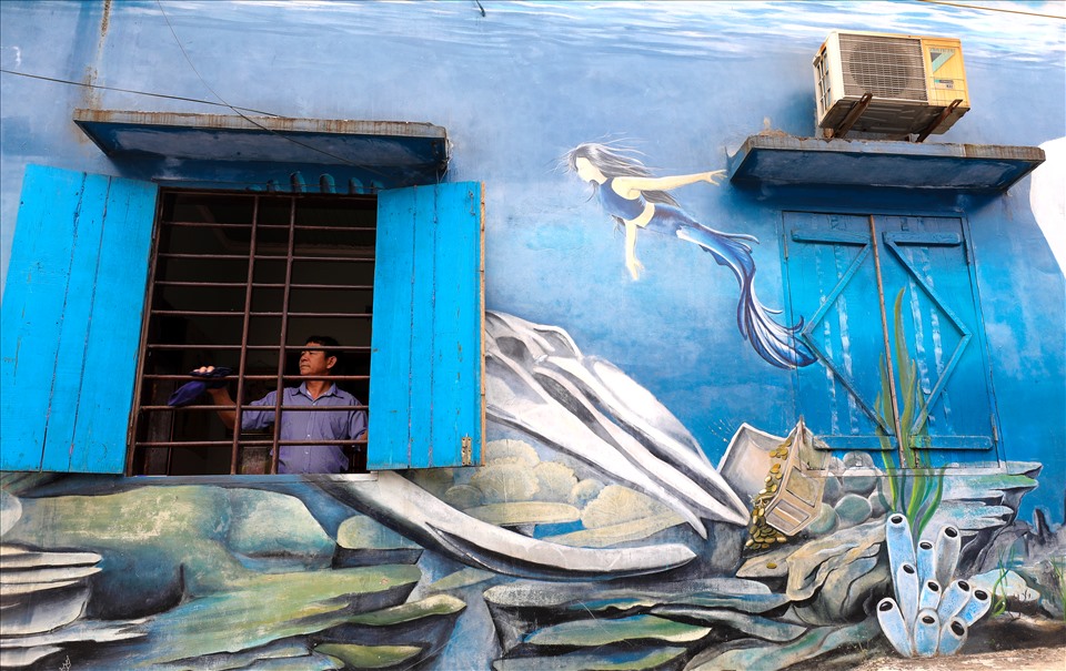 Sự tài tình của họa sĩ khi phối bức bích họa bên những khung cửa sổ ở làng  Cảnh Dương.