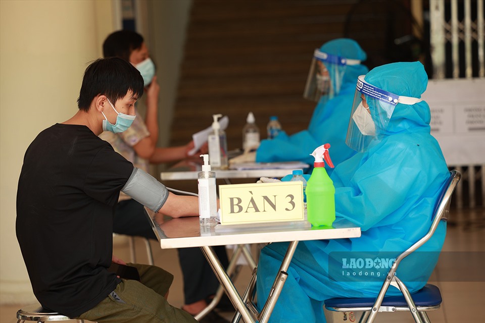 Người dân được đo huyết áp, khám sàng lọc trước khi tiêm vaccine phòng COVID-19. Ảnh: Hải Nguyễn