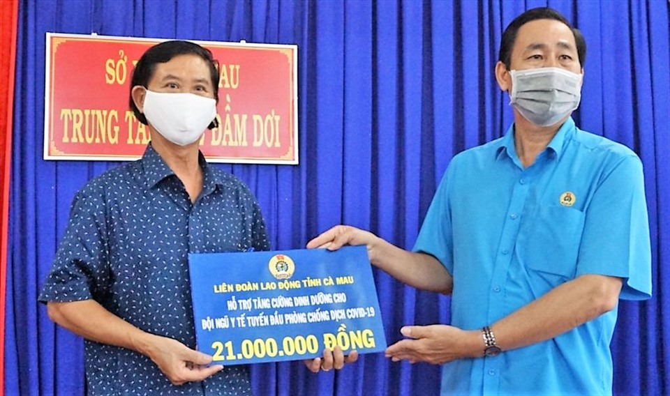 Phó Chủ tịch Thường trực Liên đoàn Lao động tỉnh Cà Mau Nguyễn Quốc Tiến (phải) trao hỗ trợ tại Trung tâm Y tế huyện Đầm Dơi.
