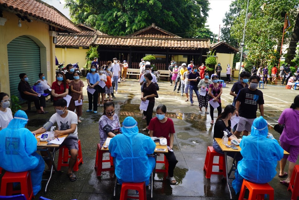 Ghi nhận của PV Lao Động tại điểm tiêm Trường Tiểu học Ngã Ba Giồng, đường Dương Công Khi, Ấp 1, Hóc Môn, TPHCM vào tối 19.8, xuất hiện cơn mưa dông lớn, thế nhưng nhiều người dân vẫn đội mưa tới điểm tiêm với mong muốn được tiêm vaccine sớm.