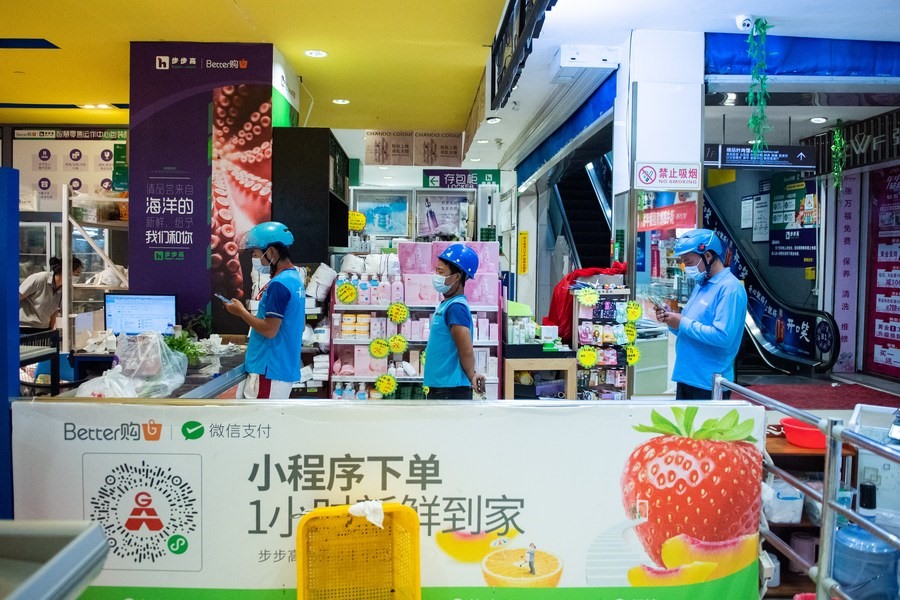 Nhân viên giao hàng chờ nhận đơn tại một siêu thị ở Trương Gia Giới, tỉnh Hồ Nam, ngày 5.8.2021. Ảnh: Xinhua