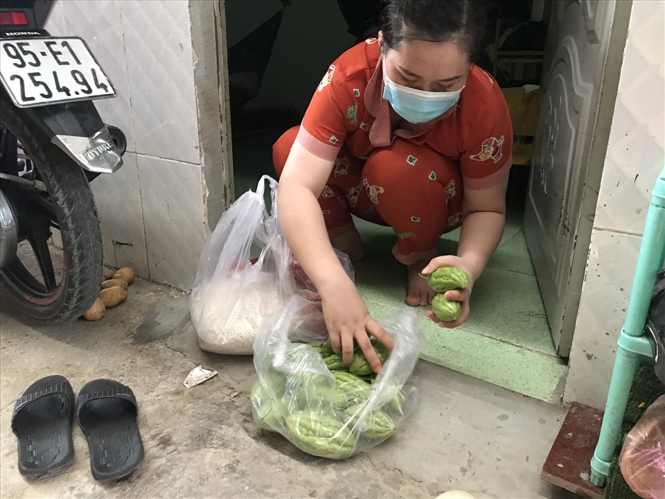 Chị Nguyễn Ngọc Vui ( 28 tuổi, công nhân Công ty Shyang Hung Cheng) đang soạn nhữ rau củ được hỗ trợ để cất ăn dần. Chị Vui đã mất việc hơn 2 tháng nay, tiền trọ, điện nước và tiền gởi về quê cho 2 con đè nặng lên vai người phụ nữ này.