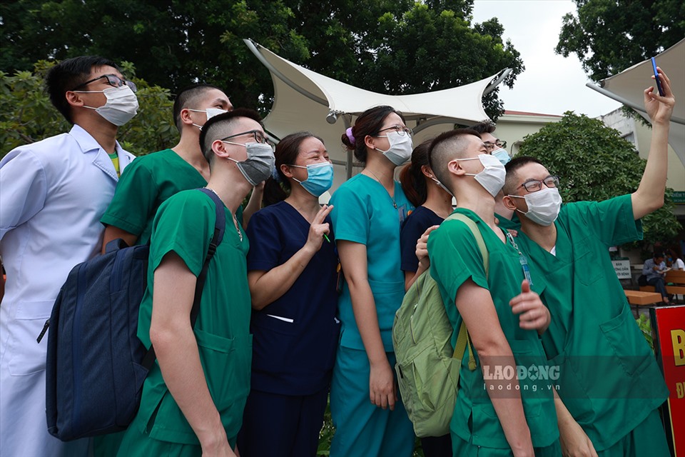 Bác sĩ Nguyễn Minh Hiếu – Trưởng nhóm Bác sĩ nội trú: “Chúng tôi tình nguyện vào tâm dịch góp sức lực cứu chữa bệnh nhân, cùng nhân dân cả nước sớm chiến thắng dịch COVID-19“. Ảnh: Bác sĩ Hiếu cầm điện thoại selfie với các đồng nghiệp trước giờ lên đường vào miền Nam. Ảnh: Hải Nguyễn