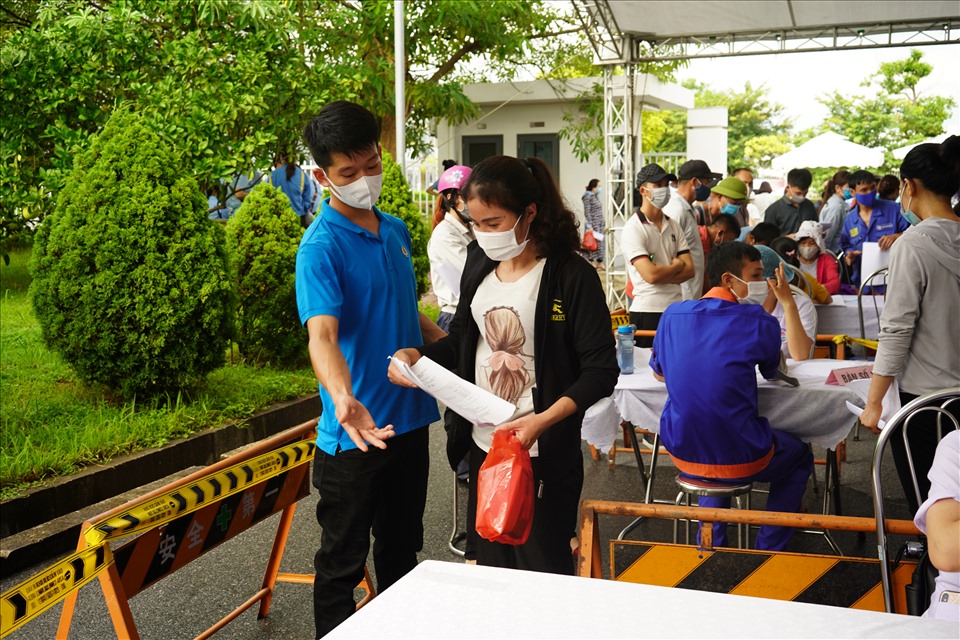 Cán bộ công đoàn hướng dẫn người lao động khu công nghiệp Nomura đến bàn tiêm vaccine. Ảnh Mai Dung