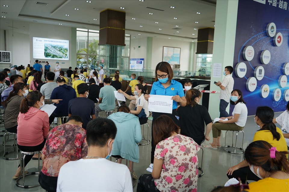 Cán bộ công đoàn cơ sở tại KCN An Dương hướng dẫn người lao động tại điểm tiêm chủng vaccine. Ảnh MD