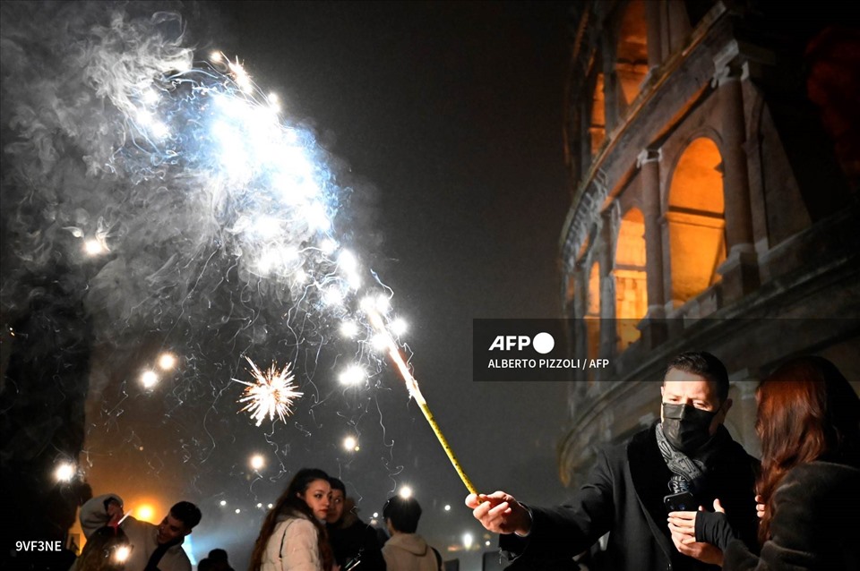 Mọi người đốt pháo bông đêm giao thừa bên ngoài đấu trường La Mã ở Rome, Italia. Ảnh: AFP