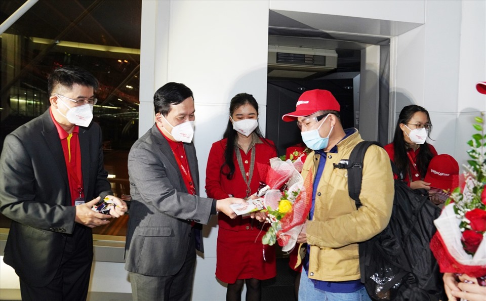 Giám đốc Điều hành Vietjet Đinh Việt Phương tặng hoa và lì xì may mắn cho hành khách trên chuyến bay đầu tiên của năm mới.