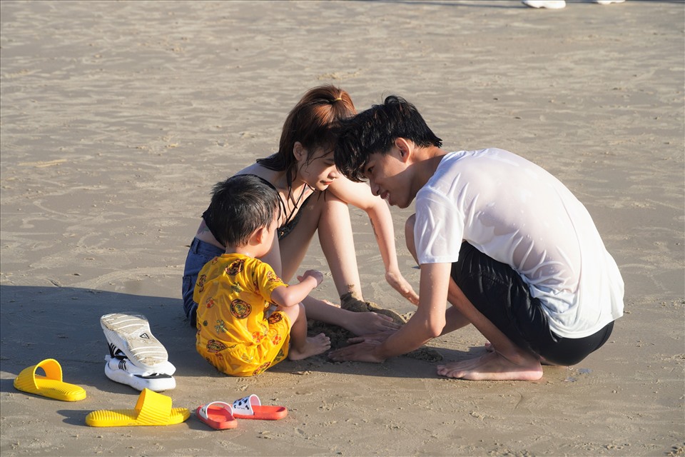 Một gia đình tắm biển và vui chơi trên bãi cát lúc khoảng 7h15 sáng đầu năm. Ảnh: T.A
