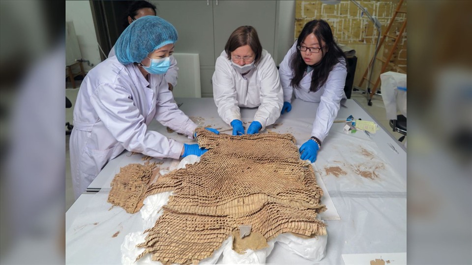 Các nhà nghiên cứu xem xét bộ áo giáp vảy da được tìm thấy trong mộ cổ Trung Quốc. Ảnh: Bảo tàng