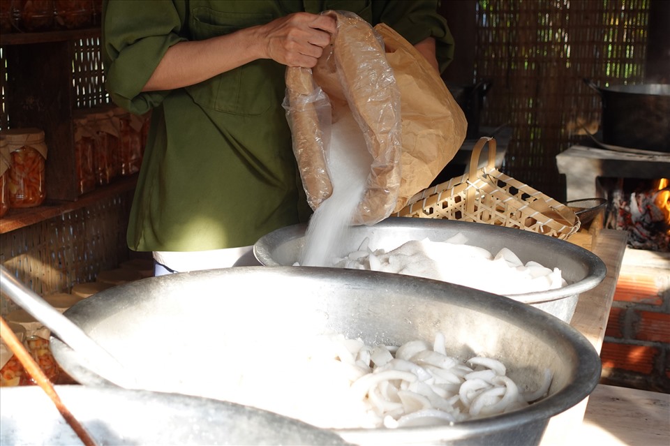 Tiếp đến là công đoạn ướp đường. Cứ 2,5 kg cơm dừa mình cho vào 1 kg đường cát trắng mịn. Hoa đậu biếc khô hãm cùng nước sôi, lấy nước cốt màu rồi ngâm cùng dừa và đường trong 2h.