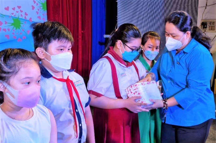 Bà Lê Thị Kim Thúy, Phó Chủ tịch LĐLĐ TPHCM, trao học bổng cho các em học sinh con công nhân lao động có hoàn cảnh khó khăn do ảnh hưởng của dịch COVID-19. Ảnh: Nam Dương
