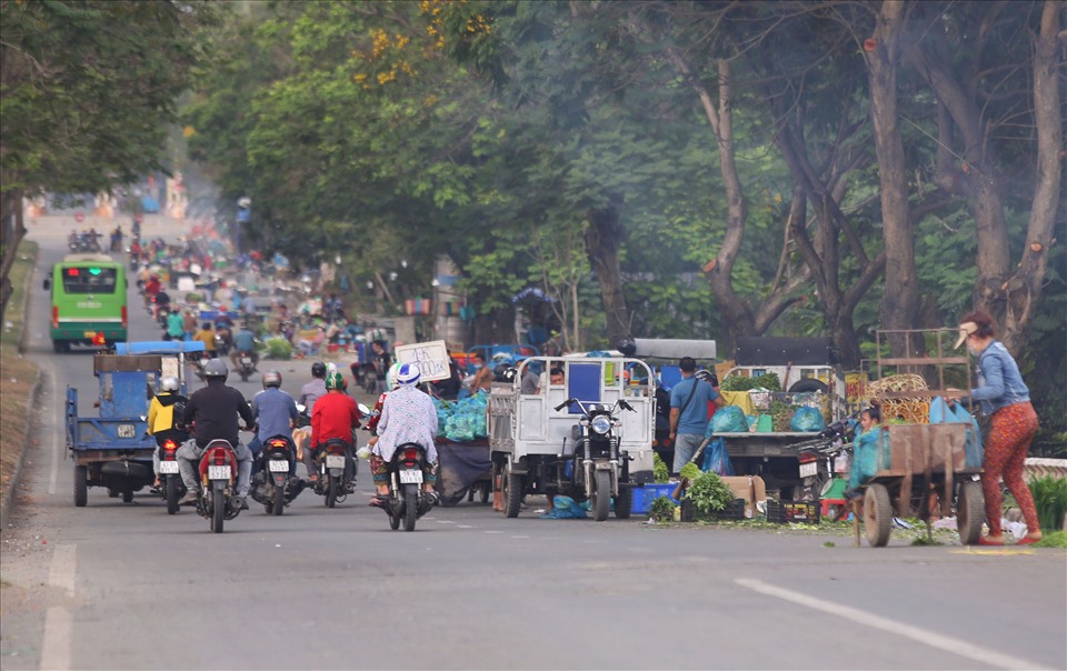 Ghi nhận của báo Lao Động trong sáng 10.1, dọc tuyến đường Nguyễn Văn Linh kéo dài hơn 1 km trước khi rẽ vào chợ đầu mối Bình Điền xuất hiện hàng chục điểm bán hàng tự phát gây cản trở giao thông.