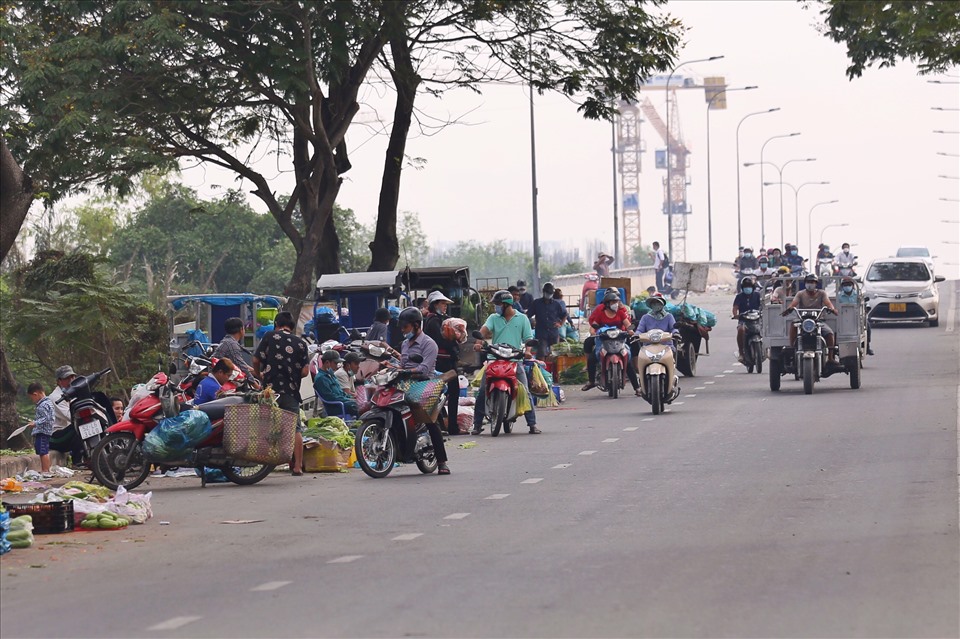 Hàng chục điểm bán hàng tự phát lấn sâu ra lòng đường Nguyễn Văn Linh gây cản trở giao thông. Ảnh: Thanh Vũ