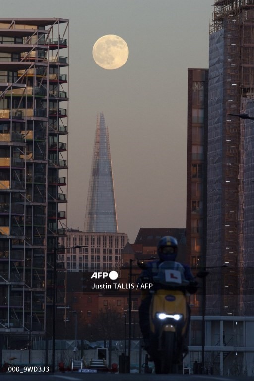 Mặt trăng mọc phía sau một tòa nhà chọc trời ở London, Anh. Ảnh: AFP