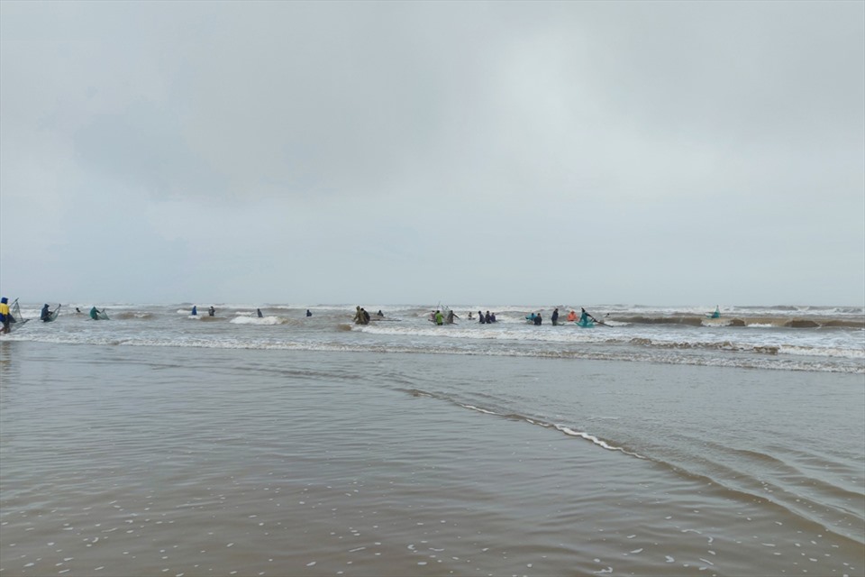 Những thanh niên khỏe mạnh ra biển nơi sâu ngang đầu gối dùng vợt vớt sò. Ảnh: TT.