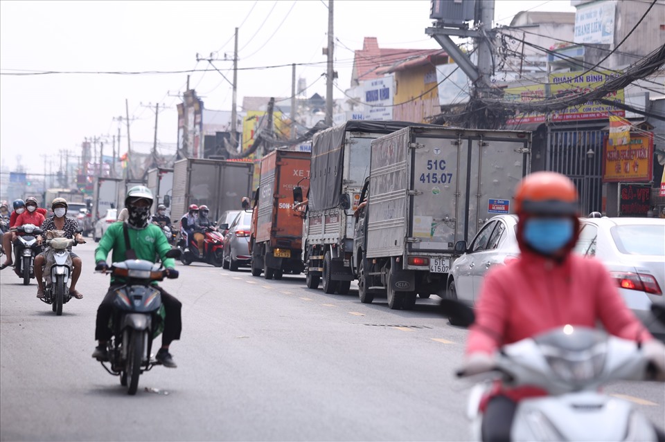 Xe cộ “xếp hàng” dài trên đường Quốc lộ 50 (huyện Bình Chánh) vào trưa ngày 20.1.