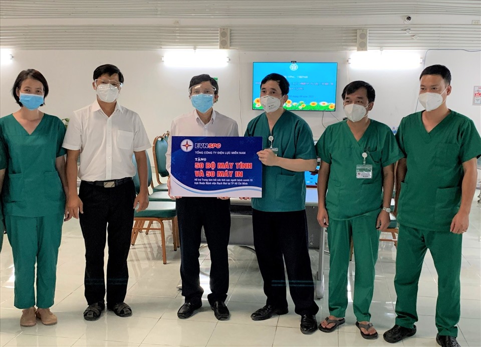 Ông Lê Xuân Thái (thứ ba từ trái qua) - Chủ tịch Công đoàn EVNSPC tăng thiết bị máy tính, máy in phục vụ quản lý, điều trị bệnh nhân COVID-19 cho Bệnh viện Bạch Mai tại TPHCM. Ảnh: Đức Long