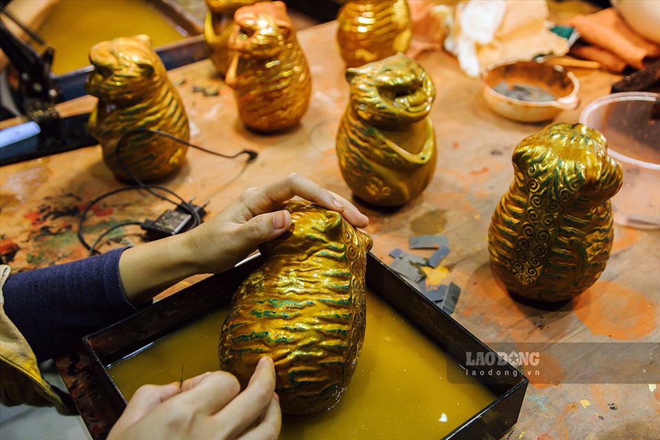 Lớp sơn bên ngoài dùng chất liệu sơn mài truyền thống kết hợp trang trí với lá vàng công nghiệp. Những lớp sơn sẽ được mài đi một cách khéo léo, tỉ mỉ, làm hiện dần những nét màu ẩn bên dưới.