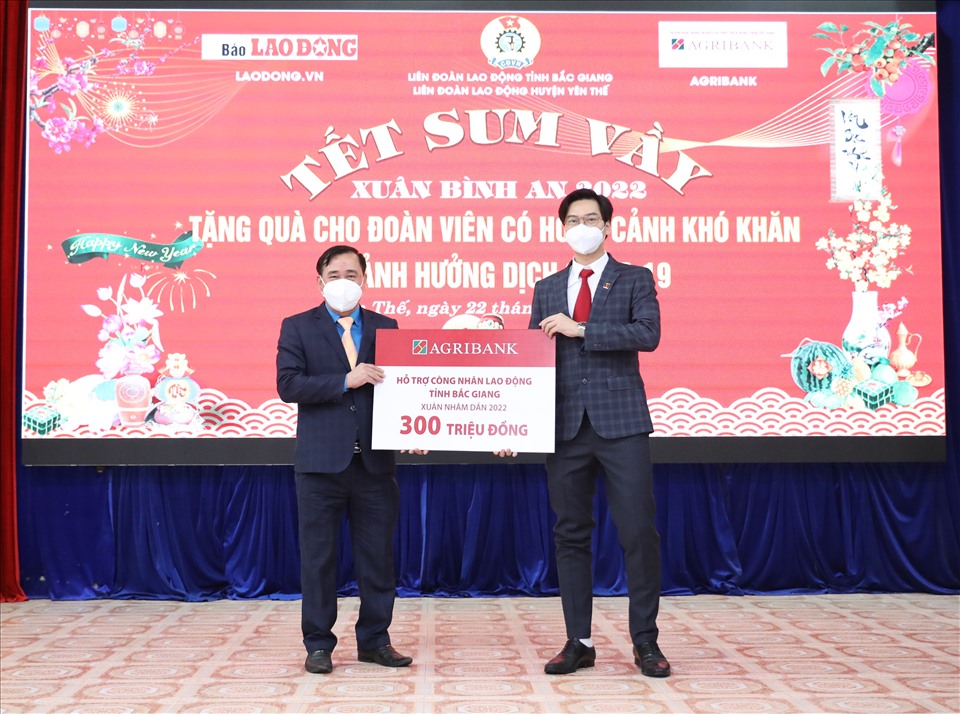 Đại diện Agribank (bên phải) trao biển hỗ trợ 300 triệu đồng tới lãnh đạo LĐLĐ tỉnh Bắc Giang. Ảnh: Hà Anh