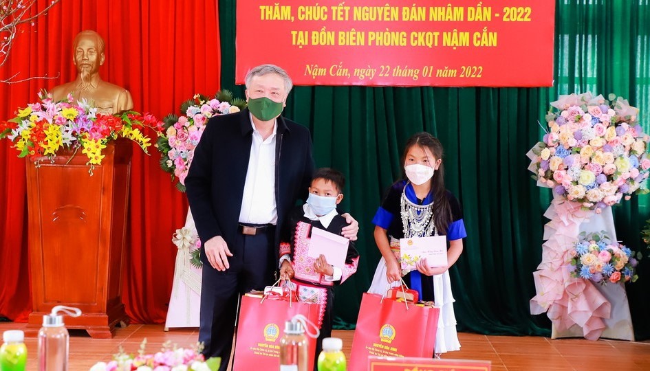 Chánh án Tòa án nhân dân tối cao Nguyễn Hòa Bình tặng quà cho 2 em nhỏ là con nuôi của Đồn Biên phòng Cửa khẩu quốc tế Nậm Cắn. Ảnh: Thành Duy/Báo Nghệ An
