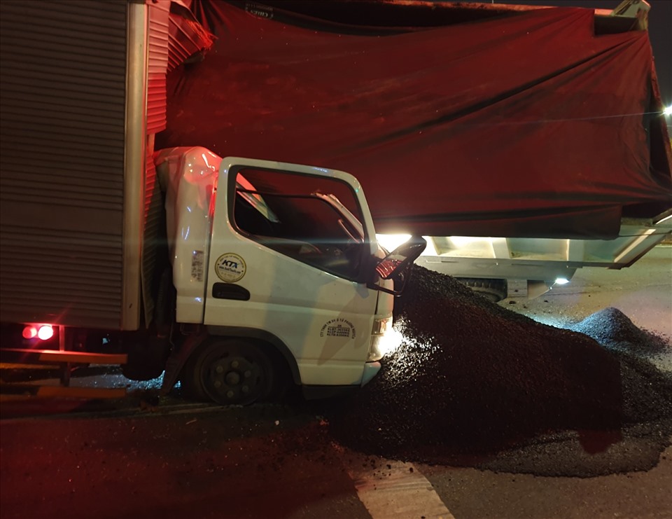 Nhựa đường nóng ở xe ben đổ tràn sang cabin xe tải. Ảnh: T.H