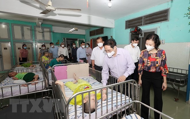 Thủ tướng Phạm Minh Chính thăm trẻ em đang được chăm sóc tại Trung tâm bảo trợ trẻ tàn tật mồ côi Thị Nghè.   Ảnh: TTXVN