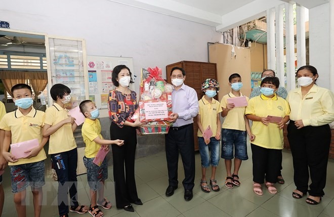 Thủ tướng Phạm Minh Chính tặng quà cho cán bộ, nhân viên và trẻ em Trung tâm Bảo trợ trẻ tàn tật mồ côi Thị Nghè.   Ảnh: TTXVN