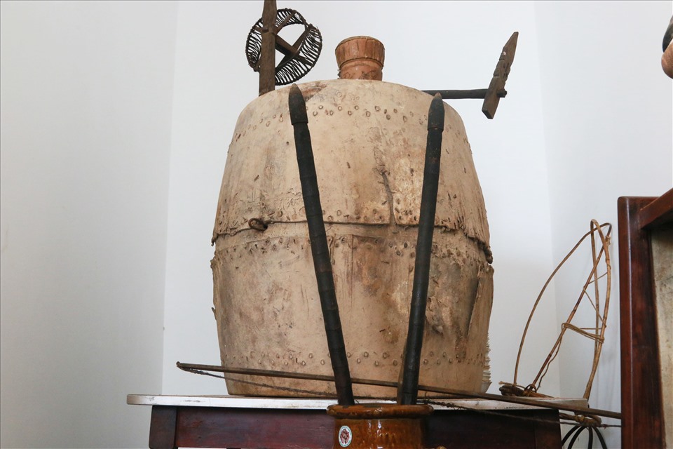 Chiếc trống da trâu được sử dụng những dịp lễ hội, hai cây gậy đâm lỗ tra hạt xưa được sử dụng đầu mùa vụ lúc gieo hạt trồng rẫy. Phía trên là khung kéo sợi để làm thổ cẩm của người đồng Tây Nguyên