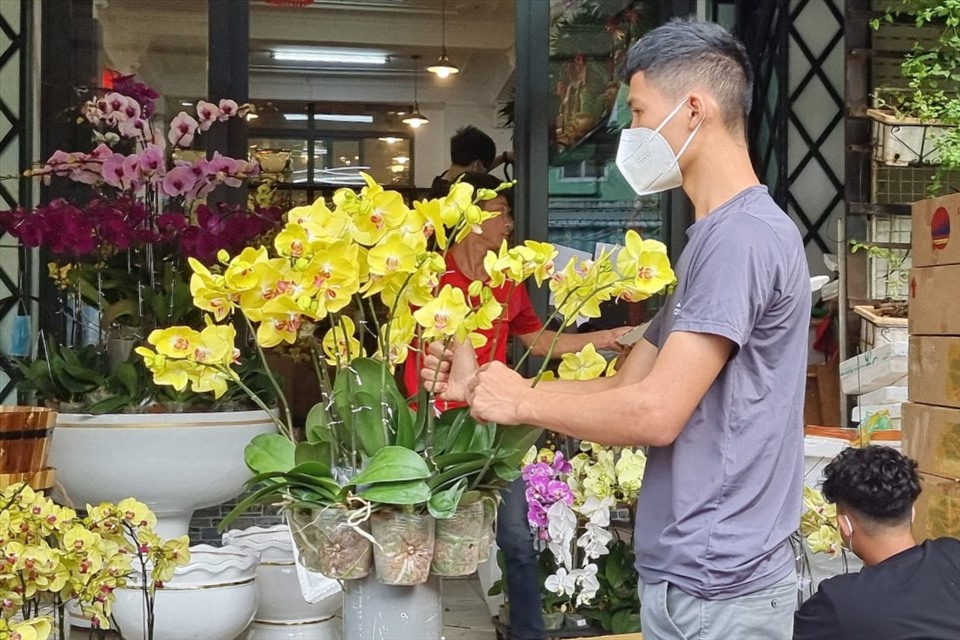 Những shop hoa tươi cũng bày ra mặt tiền những chậu hoa Lan đã cắm, hoặc cho nhân viên cắm hoa ngay trước vỉa hè để có thể vừa làm vừa thu hút khách.