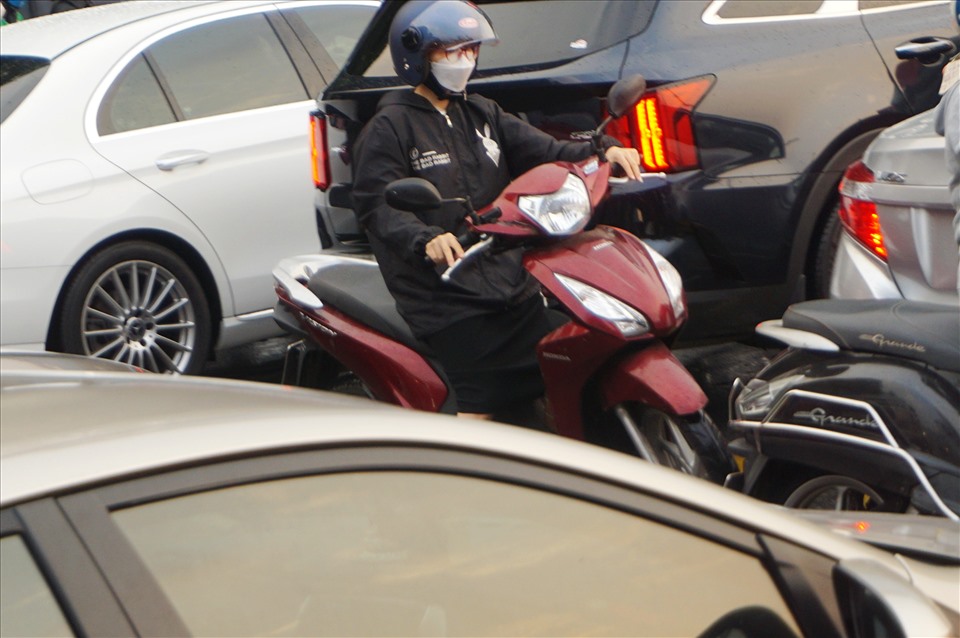 Một người chạy xe máy bị “kẹp” trong vòng vây ô tô.