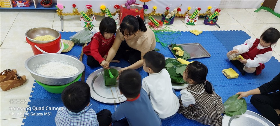 Cô trò Trường Mầm non Quảng Minh tham gia hoạt động trải nghiệm gói bánh chưng. Ảnh: NVCC.