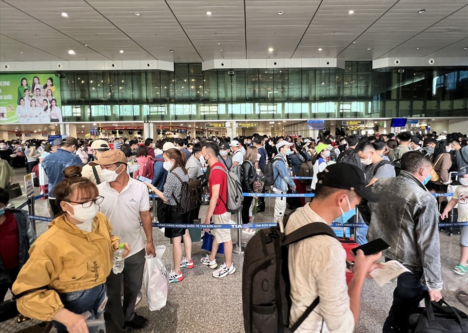 Bên trong khu vực sảnh, hành khách đứng xếp hàng dài ở các làn chờ trước khu vực chờ làm thủ tục trước chuyến bay và khu vực kiểm tra an ninh.