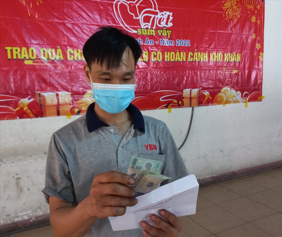 Anh Phan Văn Long phấn khởi khi phần quà là 1 triệu đồng tiền mặt, số tiền này anh sẽ mua thêm đồ ăn và quần áo cho con. Ảnh: Đình Trọng