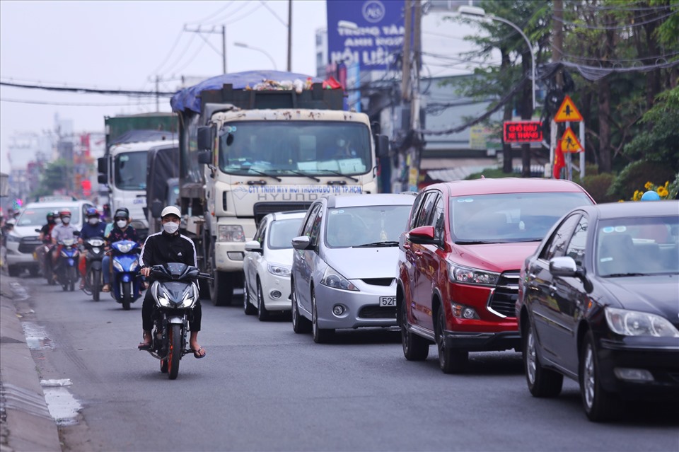 Xe ô tô, xe tải trên Quốc lộ 50 (huyện Bình Chánh) phải “xếp hàng” dài khi di chuyển qua giao lộ Quốc lộ 50 - Nguyễn Văn Linh. Tuy nhiên, các phương tiện chỉ di chuyển chậm chứ không xảy ra ùn tắc.