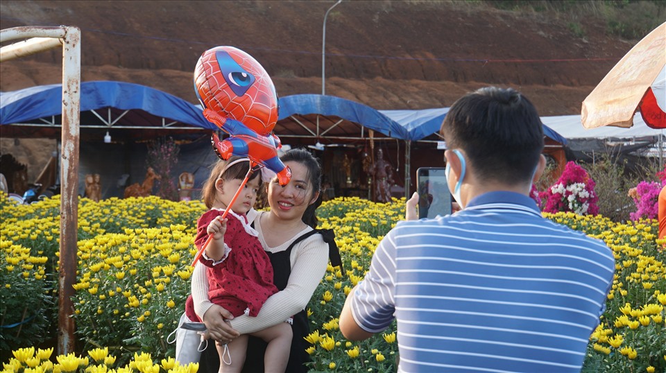 Người dân đi thăm quan, chụp hình tại chợ hoa Tết ở Đắk Nông. Ảnh: Phan Tuấn