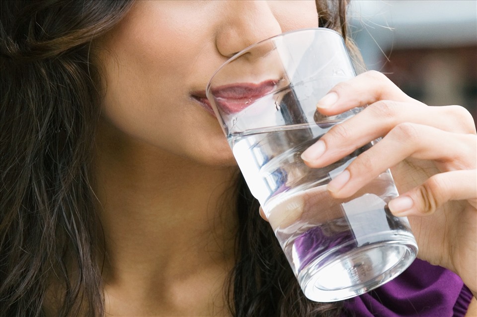 Uống nước ấm sau khi ăn no sẽ giúp cơ thể thanh lọc, đào thải các chất béo trong cơ thể. Ảnh: Xinhua
