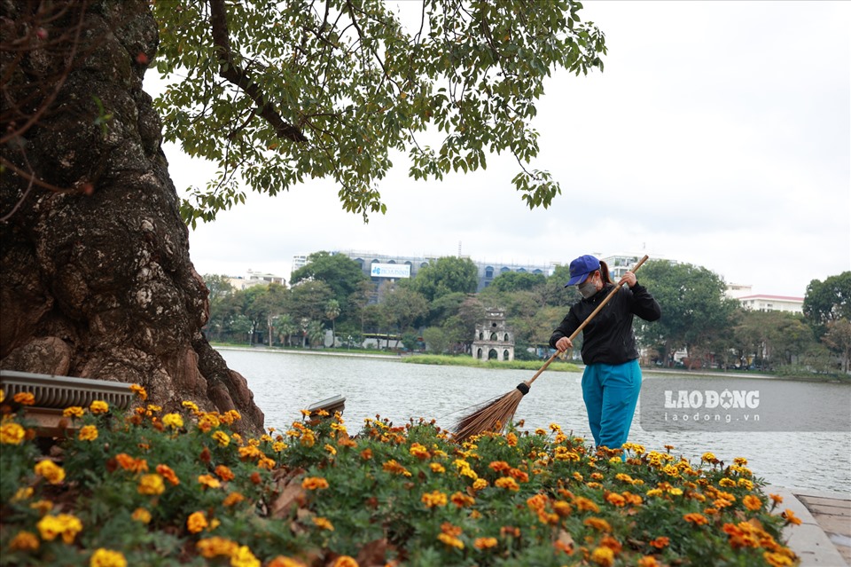 Chị Phùng Thu Hà - nhân viên Công ty môi trường đô thị Hà Nội quét dọn khu vực bờ Hồ ngày 29 Tết.