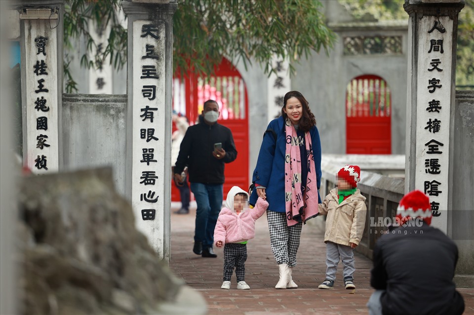 Tranh thủ lúc vắng người, một số gia đình đã bỏ khẩu trang để chụp ảnh Tết sau đó đeo lại để tuân thủ quy định phòng chống dịch.