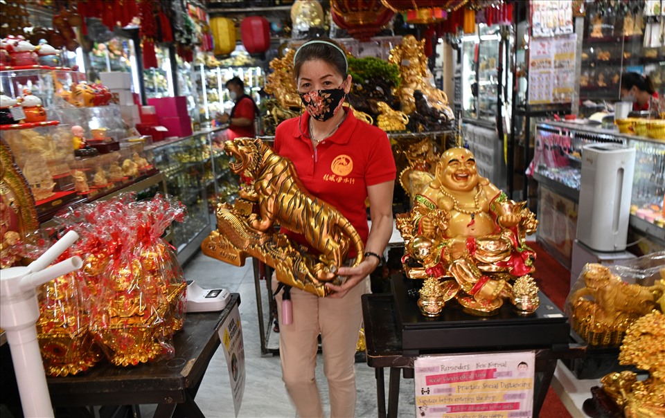 Một người bán hàng mang bức tượng hổ bày bán ở khu Chinatown của Manila, Philippines ngày 28.1, chỉ vài ngày trước Tết Nhâm Dần 2022. Ảnh: AFP