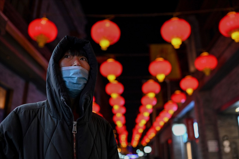 Một người phụ nữ trên phố Qianmen ở Bắc Kinh, Trung Quốc đêm giao thừa Tết Nhâm Dần 2022. Ảnh: AFP