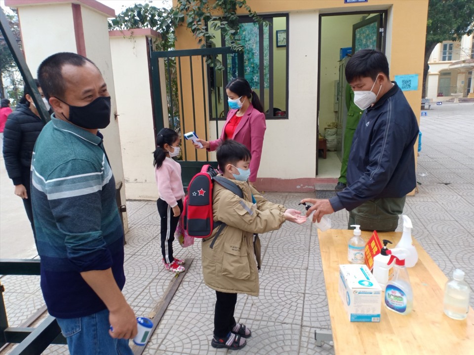 Học sinh Trường tiểu học Tam Đồng (Mê Linh) được đo thân nhiệt, sát khuẩn ở khu vực cổng trường. Ảnh: NVCC.